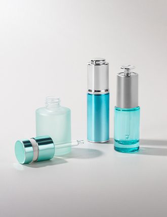 Collection of various push-button droppers with different finishes and container sizes, displayed on a grey background.